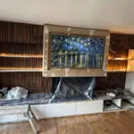 London builders and electricians renovating a living room with wooden slat panelling, built‑in shelves and lighting.