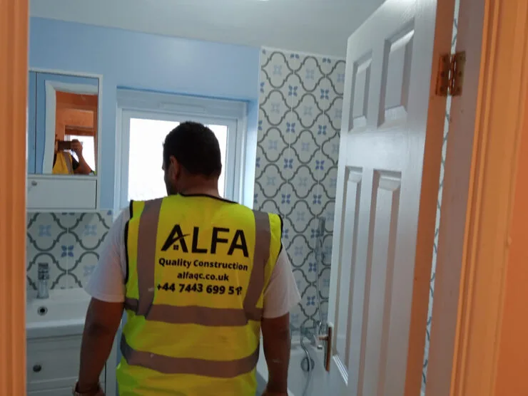 London builders and electricians carrying out a bathroom refurbishment wearing an Alfa Quality Construction vest.